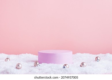 Pink round podium or stage for product display in snow with pink baubles for Christmas or winter season