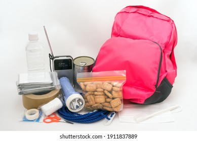 Pink rucksack and disaster prevention goods in front of light gray background