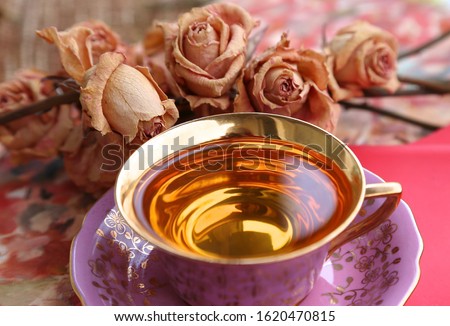 Pink sash with tea with golden bottom and little roses on pink background on Valentine 's Day