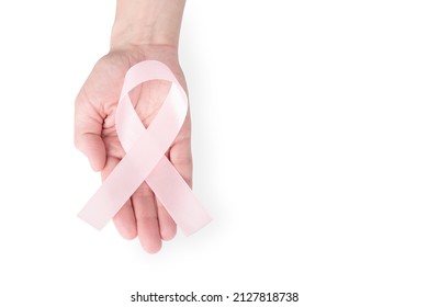 Pink Satin Ribbon On The Palm Of A Woman, Isolated On A White Background. Cancer Awareness Symbol, Women's Health, Breast Cancer. Copy Space. High Quality Photo