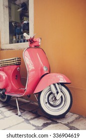 Pink Scooter Leaning Against A Wall In Italy