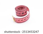 Pink sewing tape measure rolled up on a white background. Tailor