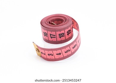 Pink sewing tape measure rolled up on a white background. Tailor's tool for accurate measurements. Fabric measuring tape. Sewing accessory for fashion design and dressmaking.