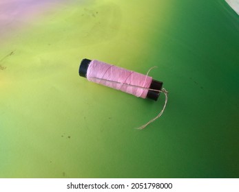 pink sewing thread with a needle