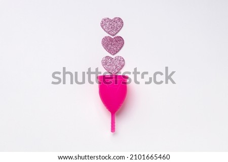 Pink silicone menstrual cup on white background