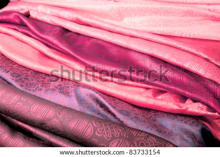 Pink silk fabric from India in a stack.