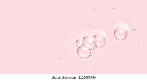 Pink Skincare Background. Water Toner Serum Oil Surface With Bubbles. Abstract Cosmetic Liquid Macro