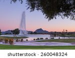 Pink sky behind one of the tallest fountains in the world in Fountain Hills, AZ with Fire Rock and Four Peaks in the background