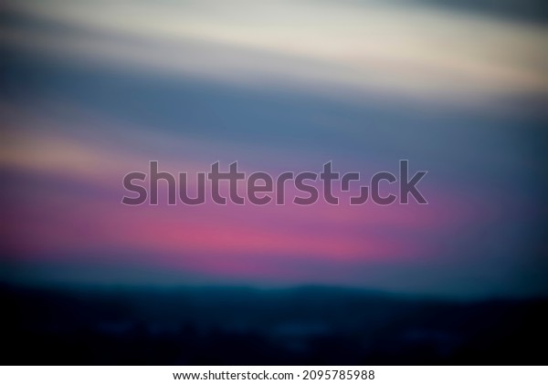 Pink sky over an urban area. Dreamy sunset\
colors, dark forest, textjred cloudscape, evening sunlight. No\
selective focus, blurred\
background.