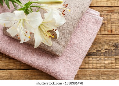 Pink Soft Terry Towel With Bouquet Of White Lily Flowers On Wooden Boards. Top View.