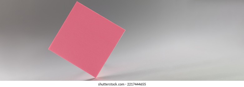 Pink Square Sticker Standing On Sharp Edge On Grey Background