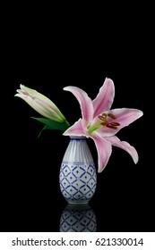 Pink Stargazer Lily In Vase Isolated On Black Background