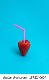 Pink Straw In Fresh Strawberry Filled With Juice Against Sky Blue Cyan Background. Minimal Summer Fruit Concept. Food Art.