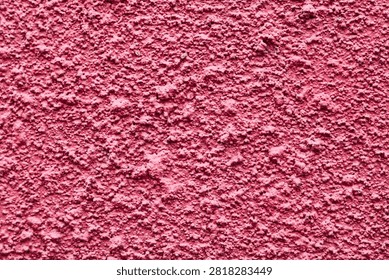 A pink stucco surface featuring a bold, roughcast texture.