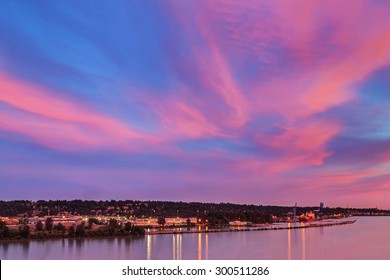 Pink Sunset Clouds With Blue Sky Reflecting On The River