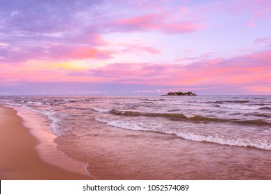 Pink sunset on lake beach sea sand beautiful colors in the sky clouds with island in the distance, Lake Malawi, Malawi, Africa