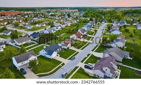 Pink sunset suburban homes neighborhood aerial HOA two-story and one-story houses