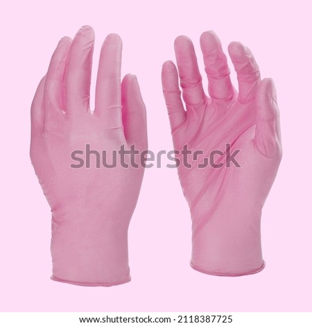 Pink surgical medical gloves isolated on white background with hands. Rubber glove manufacturing, human hand is wearing a latex glove. Doctor or nurse putting on nitrile protective gloves