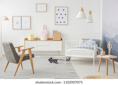 Pink Table And Grey Wooden Armchair In Girl's Bedroom Interior With Mockup Of Empty Poster