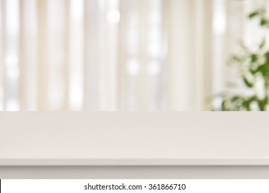 Pink table on defocuced window with curtain background