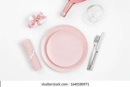 Pink Table Setting With Wine, Gift, Napkin On A White Background. Romantic Or Wedding Dinner. Valentines Day Or Mothers Day Background. Copy Space, Top View, Flat Lay.