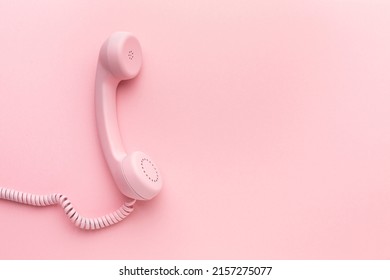 Pink telephone receiver on pink background . High quality photo