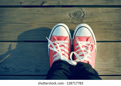 Pink Tennis Shoes On A Beach Boardwalk