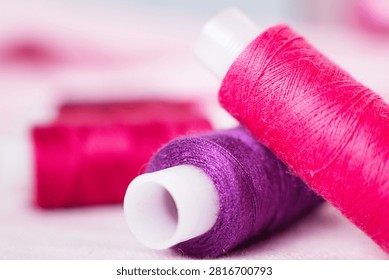 Pink thread spool on white surface, sewing, thread, crafting