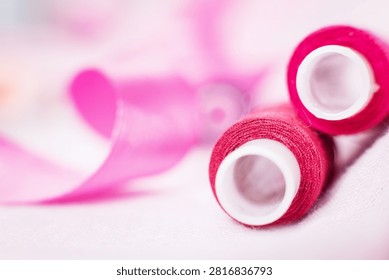 Pink thread spool on white surface, sewing, thread, crafting