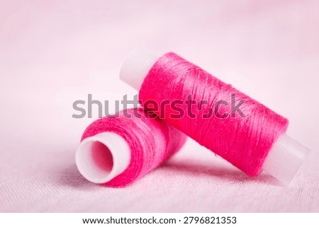 Pink thread spool on white surface, sewing, thread, crafting