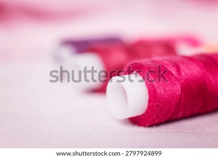 Pink thread spool on white surface, sewing, thread, crafting