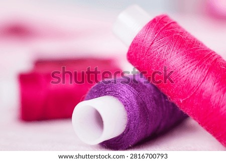 Pink thread spool on white surface, sewing, thread, crafting