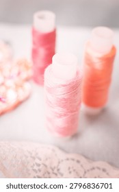 Pink thread spools and lace on white surface, sewing, threads, c