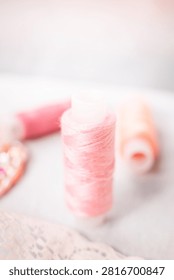Pink thread spools and lace on white surface, sewing, threads, c