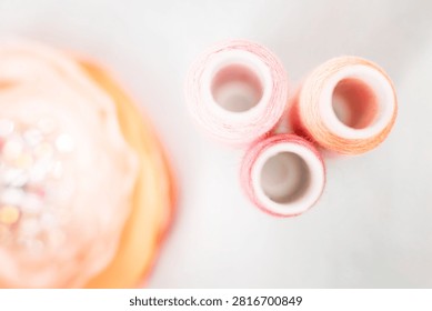 Pink thread spools and lace on white surface, sewing, threads, c