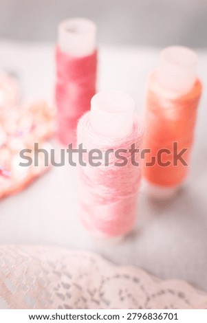 Pink thread spools and lace on white surface, sewing, threads, c