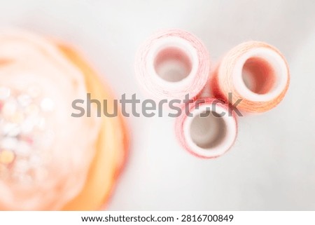 Pink thread spools and lace on white surface, sewing, threads, c