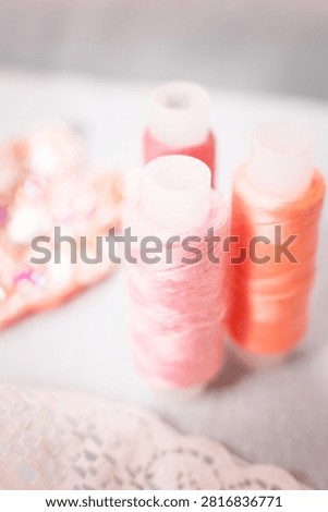 Pink thread spools and lace on white surface, sewing, threads, c