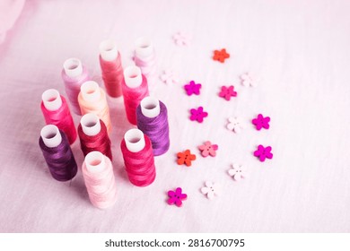 Pink thread spools scattered on white surface, sewing, threads, 