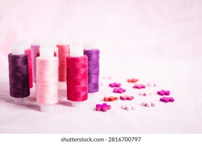 Pink thread spools scattered on white surface, sewing, threads, 
