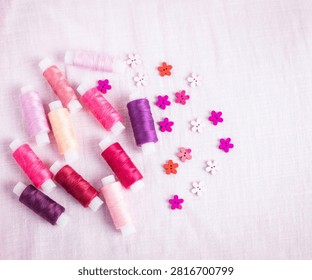 Pink thread spools scattered on white surface, sewing, threads, 