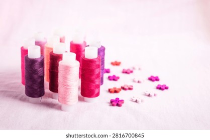Pink thread spools scattered on white surface, sewing, threads, 