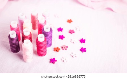 Pink thread spools scattered on white surface, sewing, threads, 