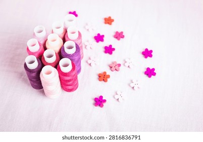 Pink thread spools scattered on white surface, sewing, threads, 