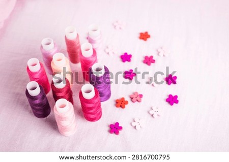 Pink thread spools scattered on white surface, sewing, threads, 