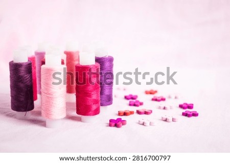 Pink thread spools scattered on white surface, sewing, threads, 