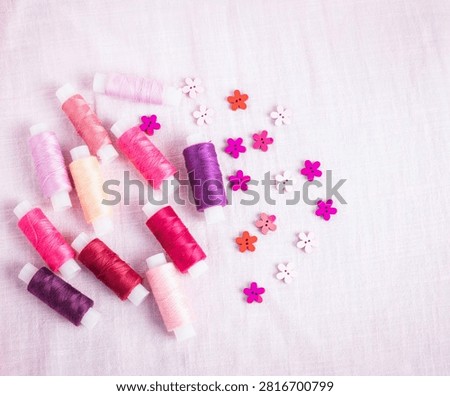 Pink thread spools scattered on white surface, sewing, threads, 