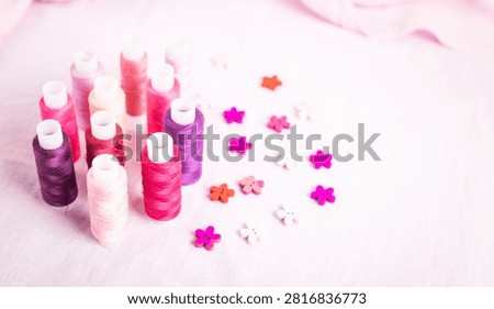 Pink thread spools scattered on white surface, sewing, threads, 