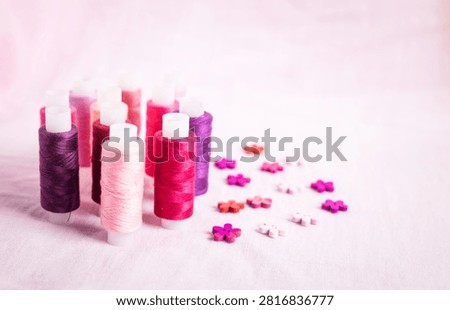Pink thread spools scattered on white surface, sewing, threads, 
