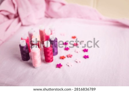 Pink thread spools scattered on white surface, sewing, threads, 